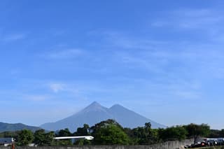 El volcán Fuego (izquierda) y el volcán Acatenango se observan en Escuintla, Guatemala, el 5 de agosto de 2026, tras la potente erupción del volcán Fuego, que obligó a realizar evacuaciones.