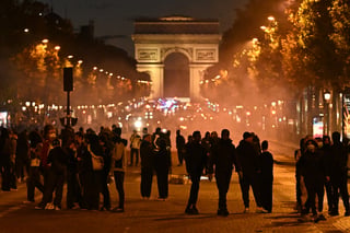 Protesters gather on the Champs-Elysees Avenue with the Arc de Triomphe in the background during a demonstration to protest against the "high cost of living", in Paris on October 17, 2026 as part of a nationwide call for mobilisation bringing together various groups expressing their anger: former "Yellow Vest", secondary school and university students, climate activists and even farmers. After weeks of student protests, France faces broader, nationwide demonstrations on October 17, 2026 over the cost of living, setting up a potentially fraught six months heading into a presidential election. A police source told AFP that authorities estimated nearly 200,000 people could take part, with 40,000 in Paris. (Photo by Guillaume Saligot / AFP)