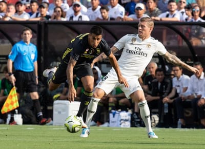 Juventus' Joao Cancelo (L) passes Real Madrid's Toni Kroos during an International Champions Cup (ICC) match at Fedex Field in Landover, Maryland, on August 4, 2018. / AFP PHOTO / NICHOLAS KAMM