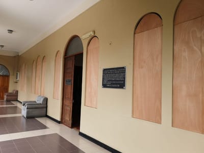 Este miércoles la Asamblea Legislativa reforzó nuevamente la seguridad en sus oficinas, colocando madera en las ventanas. Foto CRH