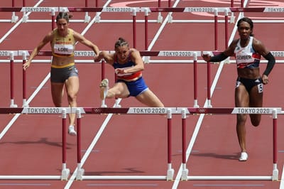 Costa Rica's Andrea Carolina Vargas (C) wins the women's 100m hurdles heats during the Tokyo 2020 Olympic Games at the Olympic Stadium in Tokyo on July 31, 2021. (Photo by Giuseppe CACACE / AFP)