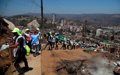 Voluntarios entregan ayuda comunitaria a los residentes afectados después de un incendio forestal en el barrio Población Monte Sinaí en Viña del Mar, Chile, el 7 de febrero de 2024 (AFP)