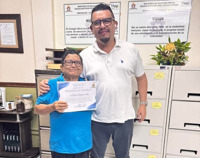 Ana Isabel Díaz Zúñiga, recibiendo su título de alumna de honor del Colegio Nocturno Enrique Menzel. A su lado, Esteban Camacho, subdirector del centro educativo