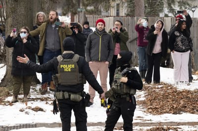 Observadores filman a agentes de ICE mientras controlan el perímetro después de que uno de sus vehículos pinchara una llanta en la Avenida Penn el 5 de febrero de 2026 en Minneapolis, Minnesota. AFP