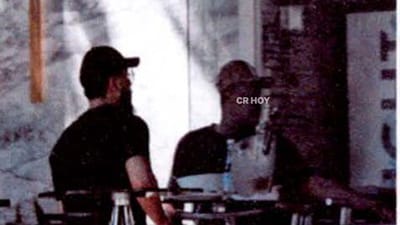 Alias "Hilario" de espaldas y de camisa negra reunido en un restaurante de Santo Domingo, República Dominicana.