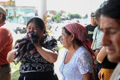 Mujeres lloran a las afueras de la funeraria donde fue trasladado el cuerpo del juez del Tribunal Agroambiental Víctor Hugo Claure, máxima autoridad judicial ambiental y agraria de Bolivia, en Santa Cruz, el 1 de mayo de 2026. AFP