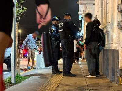 Dos oficiales de la Fuerza Pública abordan a dos jóvenes que consumían licor en vía pública. Barrio la California, viernes 8 de mayo.
