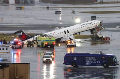 (FILES) An Air Canada Express CRJ-900 sits on the runway after colliding with a Port Authority fire truck at LaGuardia Airport in New York, on March 23, 2026. Two air traffic controllers left work early ahead of the deadly collision between an Air Canada jet and a fire truck at New York's LaGuardia Airport in March, The Wall Street Journal reported on August 27, 2026. (Photo by TIMOTHY A. CLARY / AFP)