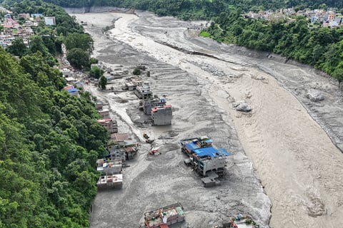 An aerial view shows houses lying deluged in sludge following flash floods in Trishuli of Nepal's Nuwakot district on August 27, 2026. Rescue teams scoured devastated zones August 27 for more than 1,300 people missing a day after flash floods and landslides along the Nepal-Tibet border killed at least 273, sweeping away entire villages. (Photo by Arun SANKAR / AFP)