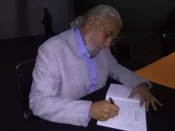 Carlos Morales, periodista y escritor, firma un ejemplar para uno de sus lectores. (Foto NPR).