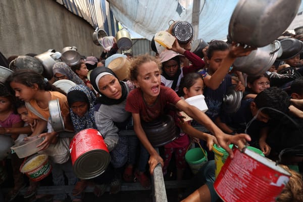 Los palestinos se reúnen para recibir comidas preparadas en un centro de distribución de alimentos en el campo de refugiados de Nuseirat, en el centro de la Franja de Gaza, el 18 de agosto de 2025. El 18 de agosto, la organización de derechos humanos Amnistía Internacional acusó a Israel de aplicar una «política deliberada» de hambruna en Gaza, mientras que las Naciones Unidas y los grupos de ayuda humanitaria advierten del riesgo de hambruna en el territorio palestino. Israel, que restringe fuertemente la ayuda que entra en la Franja de Gaza, ha rechazado repetidamente las acusaciones de hambruna deliberada en la guerra que dura ya 22 meses.