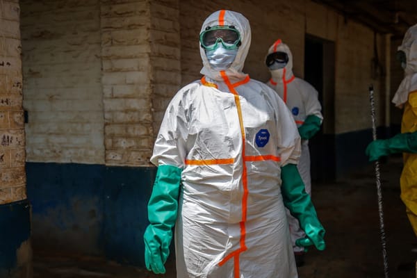 Health workers wearing protective equipment gather to disinfect the isolation area for Ebola patients at the General Referral Hospital of Mongbwalu in Mongbwalu, on May 23, 2026. Ebola continues to spread in Democratic Republic of Congo, where the first cases of transmission were reported in the eastern province of South Kivu, while the health response is struggling to get organized and has given rise to scenes of chaos in Ituri province, the epicenter of the epidemic. The World Health Organization (WHO) issued an international health alert to address a 17th Ebola outbreak in the east of the Democratic Republic of Congo, a vast Central African country of more than 100 million inhabitants plagued by conflict. (Photo by Seros MUYISA / AFP)
