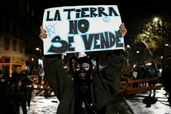 Un manifestante muestra un cartel que dice en español: 